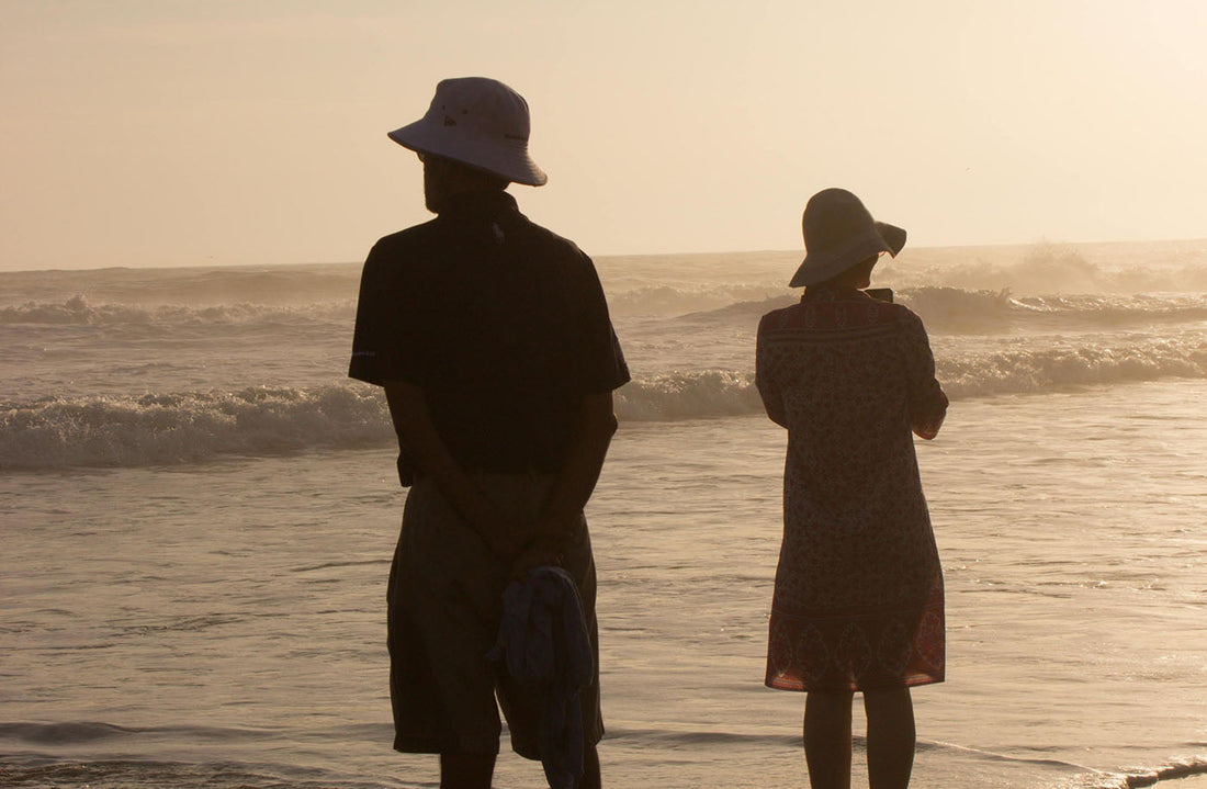 Silhouettes of two healthy people enjoying a calm beach at sunset.